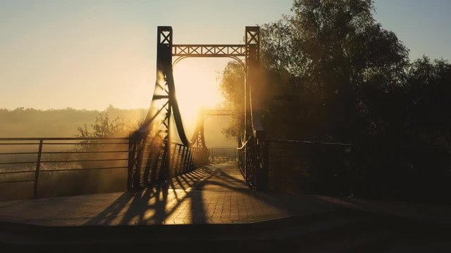 The red metal bridge over a small river on the embankment of the city of Irpin in Ukraine, low slow drone flight