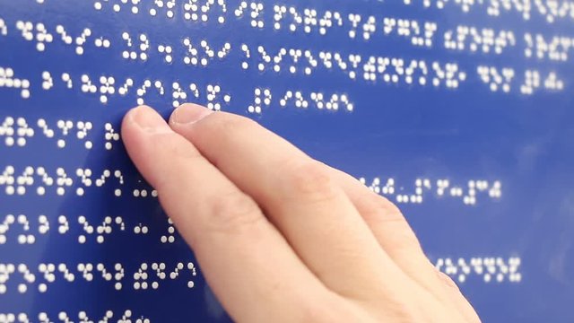 Blind man reading Braille font with hand