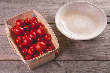 ripe tomatoes in a small wooden crate and old plate