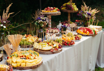 Beautiful wedding candy bar with a lot of  sweets, fruits and food. Wedding banquet table