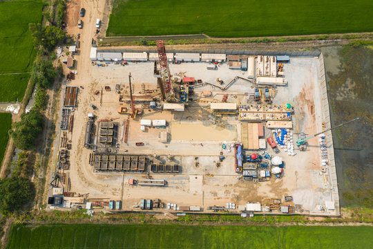 Oil And Gas Land Drilling Rig Onshore In The Middle Of A Rice Field Aerial View From A Drone