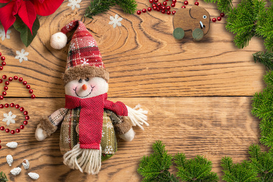 Christmas decoration and snowman rag doll on wooden background