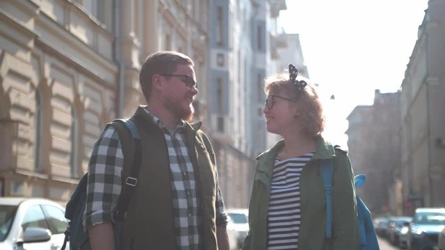 Young, pretty tourists stroll in the old town in the summer and chat.