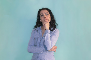 Brunette woman with her hand on her chin, thinking about some question