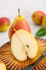 Tasty fresh pears with knife on cutting board, closeup