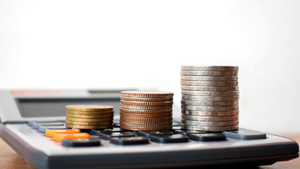 Stack coins on a calculator, financial concepts, accounts and calculations.