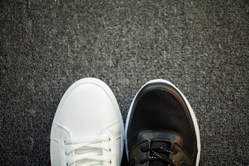 Pair of new stylish white sneakers on floor at home