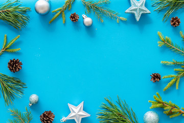 New Year decorative mockup. Fir branches and festive toys frame on blue background top view copy space