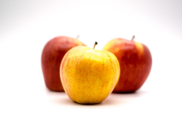 yellow apple front and center of red apples