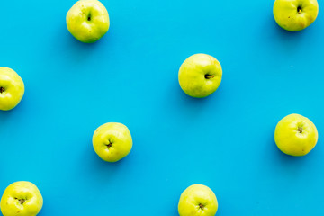 Green apples pattern on blue background top view