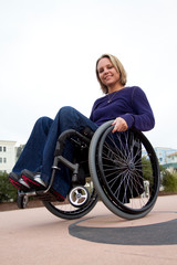 Fototapeta na wymiar Woman in Wheelchair Rocking Back - Wheelie