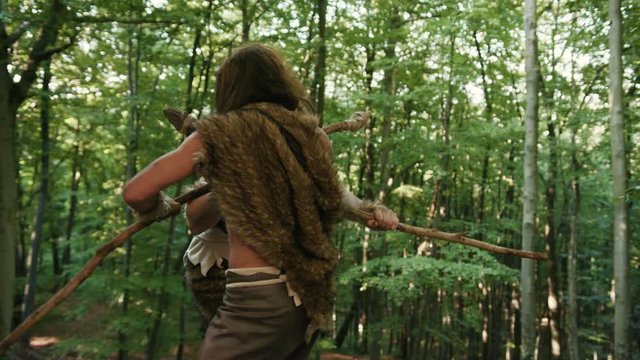 Two persistent angry wild men fighting for tribe leadership on mountain edge in prehistoric competition in jungle forest. Hunter-gatherers of stone-age period.