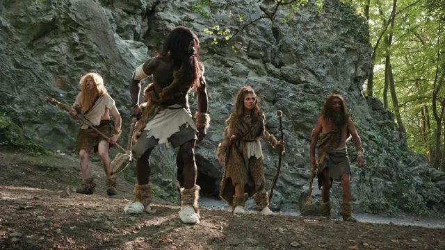 Ancient neanderthal family of hunter-gatherers exploring jungle mountain forest rejoicing with pristine nature home. Hunting primitive tribe people.