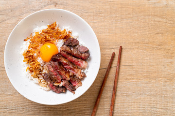 sliced beef on topped rice bowl with egg