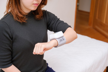 血圧を測る女性　リストバンド　健康管理　妊娠　家庭用　低血圧