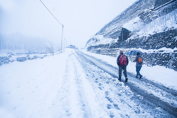 Two guys walking at heavy snowy day in the himachal. Snowfall winter concept, wide angle shot - Image