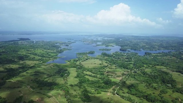 aerial view of green filds, trees, gatun lake on sunny day