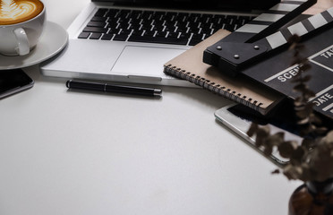 Office supplies are tablet, pen, computer, notebook, mobile phone and red coffee mug placed at an office desk and have a white background.