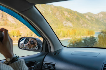 Happy traveler girl photographing Autumn nature colors.