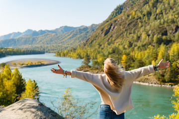 Autumn woman standing backwards and watching nature. Autumn nature colors with woman back view.