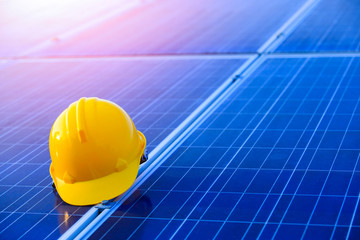 Yellow helmet with photovoltaic in the solar power plant,maintenance panels collect solar energy,concept of sustainable resources,copy space
