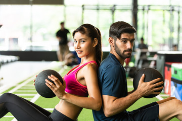 Young couples work out at the gym to strengthen the body. Each person recommends exercise for each other and encourage each other while exercising.