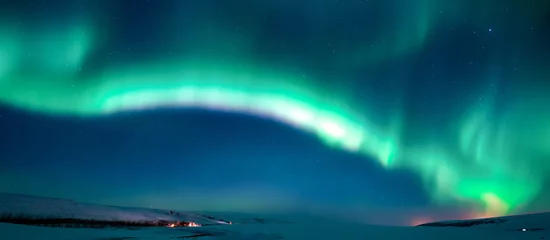 Fotobehang actieve gloeiende groene aurora borealis in de winternachthemel over het duidelijke sneeuwgebied  bannerformaat © tosspra