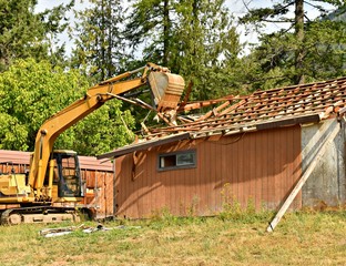 Excavator destroying house demolition