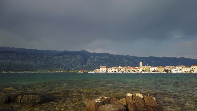Time lapse of coastal town in Croatia, mountains and cloudscape in background, panoramic view of small village and harbor, Vinjerac, Croatia, Paklenica National park in Velebit