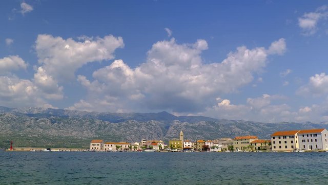 Time lapse of rolling clouds from mountain above medieval coastal village and harbor Vinjerac, Croatia, Velebit mountains and Paklenica National park in the background