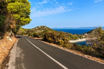 Road above the sea on the Croatian island of Lastovo. Road transport. Morning sun on the road by the sea. Asphalt road.