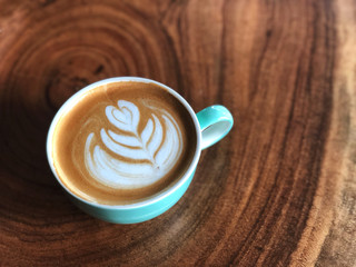 Cup of love , heart shape latte art coffee in green and white cup on the vintage wooden table. Love coffee love in your cup. Wake up and full fill energy.