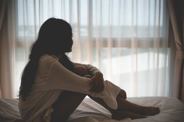 woman feel sad epressed and sitting in her bed