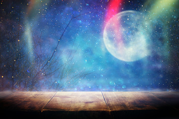 Holidays Halloween concept. Empty rustic table in front of scary and misty night sky and full moon background. Ready for product display montage