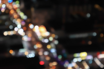 Abstract artistic aerial view of blurry colorful bokeh background from transportation and traffic light in the city for holiday season travel business.
