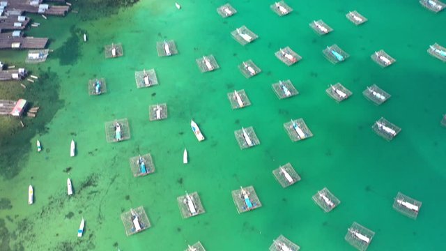 Aerial Drone Video flying above Fishing Village of Tanjung Binga in Belitung Island Indonesia. Fishing Boat on Clear water, village houses