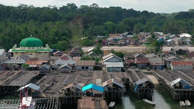 Aerial Drone Video flying above Fishing Village of Tanjung Binga in Belitung Island Indonesia. Fishing Boat on Clear water, village houses