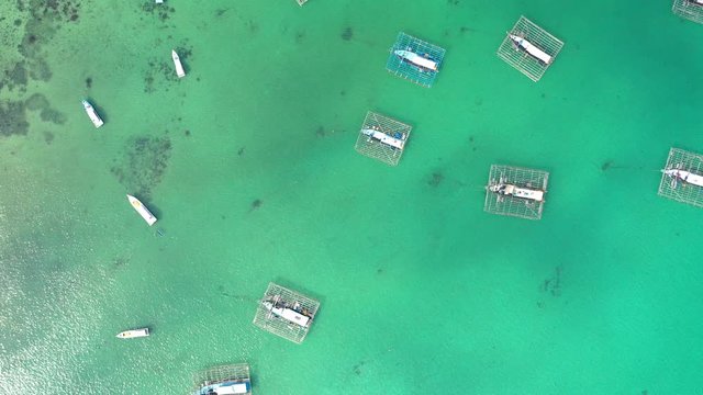 Aerial Drone Video flying above Fishing Village of Tanjung Binga in Belitung Island Indonesia. Fishing Boat on Clear water, village houses