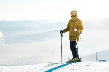 Fototapeta na wymiar Man skier stands with ski on mountain top