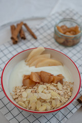 yogurt with cooked pears and home made granola on a table