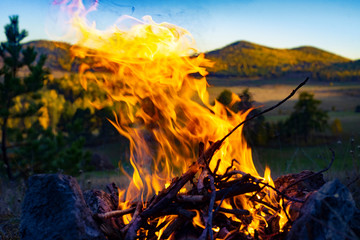 bonfire in the field on a background of hills