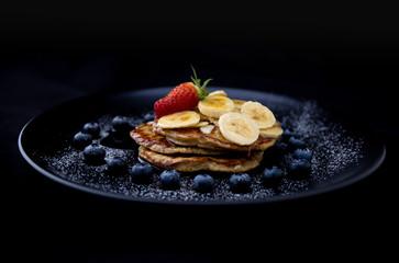 Healthy banana pancake with blueberry heart shape and strawberry