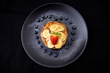Healthy banana pancake with blueberry heart shape and strawberry