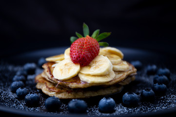 Healthy banana pancake with blueberry heart shape and strawberry