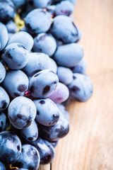 Ripe black grape on the rustic background. Selective focus. Shallow depth of field.