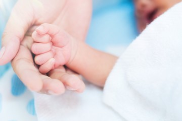 Close up hand of mother holding baby hand. Concept of love and family.