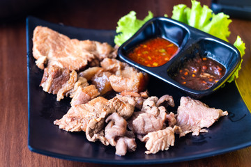 Cooked Boiled slices meat beef pork on black plate eat with dipping sweet and spicy chili sauce....