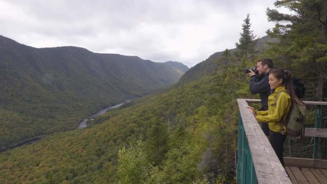 Hike couple camping with backpacks in Quebec National Park in Autumn season, Canada forest travel lifestyle. Tourists looking at view of Jacques Cartier National Park.