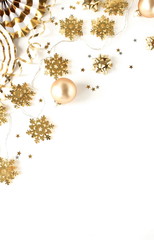 christmas or new year decorations background in gold colors on white   background with empty copy space for text. holiday and celebration concept for postcard or invitation. top view 