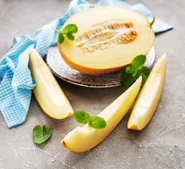 Plate with melon on a concrete background